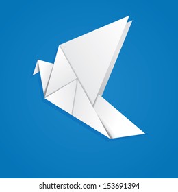 White folded paper, origami pigeon on blue background.