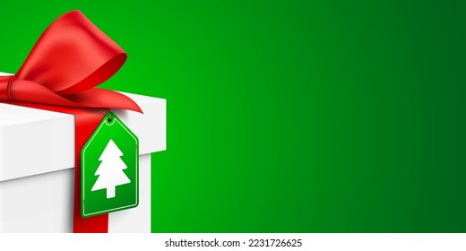 White gift box with Christmas Tree hanging tag, on a green background, realistic vector banner.
