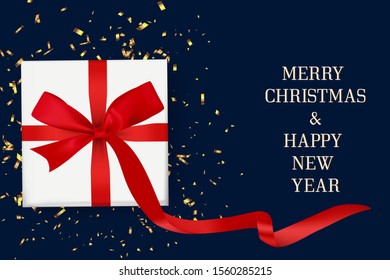 white gift box with red ribbon bow and gold confetti on blue background with merry christmas and happy new year lettering. concept for poster, banner or greeting card in christmas and new year season