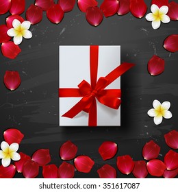 white gift box with red ribbon. rose petals . valentine`s card background
