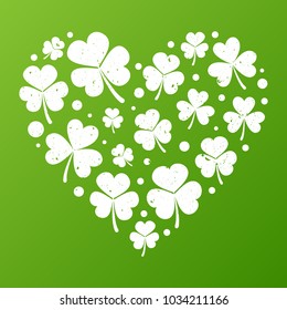White grunge and distressed heart made of small shamrock icons on green background. Vector saint patricks concept illustration