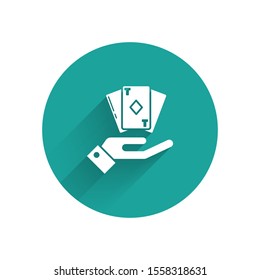White Hand holding deck of playing cards icon isolated with long shadow. Casino gambling. Green circle button. Vector Illustration