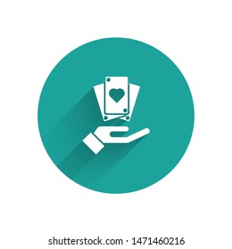 White Hand holding playing cards icon isolated with long shadow. Сasino game design. Green circle button. Vector Illustration