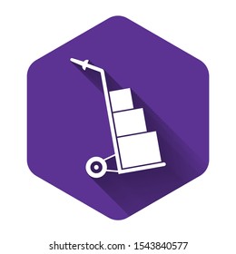 White Hand truck and boxes icon isolated with long shadow. Dolly symbol. Purple hexagon button. Vector Illustration