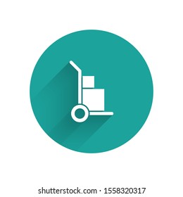 White Hand truck and boxes icon isolated with long shadow. Dolly symbol. Green circle button. Vector Illustration
