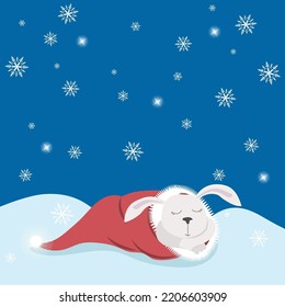 White hare or rabbit sleeping in a Santa hat on a snowy field with falling snowflakes. Holiday card, symbol of 2023