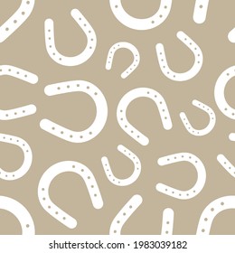 White horseshoe seamless pattern on beige background. Vector illustration.