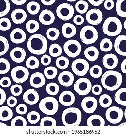 Círculos de tinta blanca aislados en un fondo azul oscuro. Patrón monocromo y sin soldadura geométrica. Dibujo gráfico plano vectorial simple a mano. Textura.