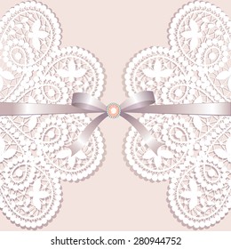 White lace with ribbon and jewelery on a beige background