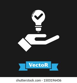 White Light bulb in hand icon isolated on black background. Concept of idea.  Vector Illustration