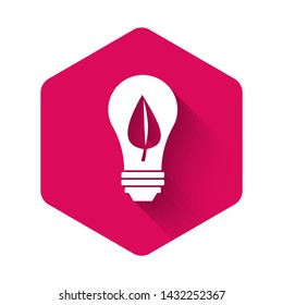 White Light bulb with leaf icon isolated with long shadow. Eco energy concept. Alternative energy concept. Pink hexagon button. Vector Illustration