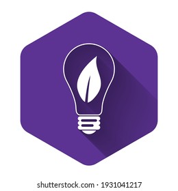 White Light bulb with leaf icon isolated with long shadow. Eco energy concept. Purple hexagon button. Vector Illustration