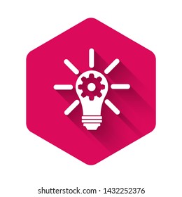 White Light bulb with rays shine and gear inside icon isolated with long shadow. Innovation concept. Pink hexagon button. Vector Illustration