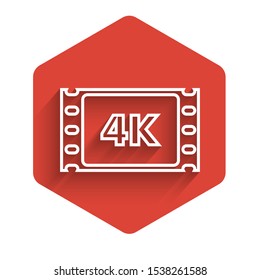 White line 4k movie, tape, frame icon isolated with long shadow. Red hexagon button. Vector Illustration