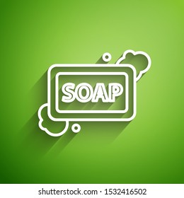 White line Bar of soap with foam icon isolated on green background. Soap bar with bubbles.  Vector Illustration