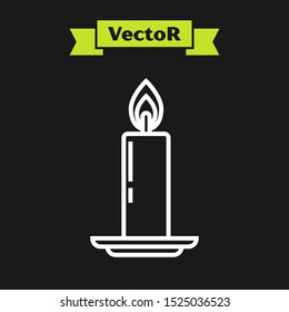 White line Burning candle in candlestick icon isolated on black background. Old fashioned lit candle. Cylindrical candle stick with burning flame.  Vector Illustration