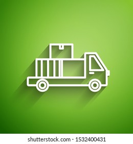 White line Delivery truck with cardboard boxes behind icon isolated on green background.  Vector Illustration