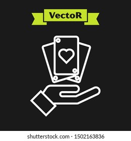 White line Hand holding playing cards icon isolated on black background. Casino game design.  Vector Illustration