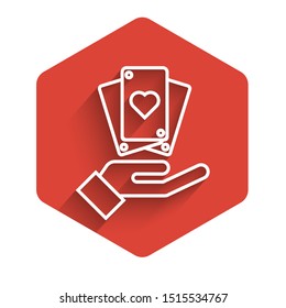 White line Hand holding playing cards icon isolated with long shadow. Casino game design. Red hexagon button. Vector Illustration