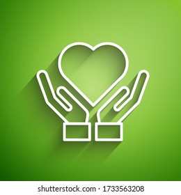 White line Heart on hand icon isolated on green background. Hand giving love symbol. Valentines day symbol.  Vector Illustration