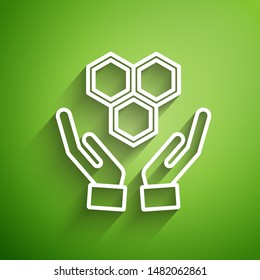 White line Honeycomb and hands icon isolated on green background. Honey cells symbol. Sweet natural food.  Vector Illustration