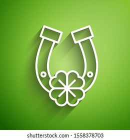 White line Horseshoe with four leaf clover icon isolated on green background. Happy Saint Patricks day.  Vector Illustration