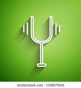 White line Musical tuning fork for tuning musical instruments icon isolated on green background.  Vector Illustration