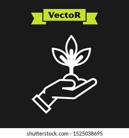 White line Plant in hand of environmental protection icon isolated on black background. Seed and seedling. Planting sapling. Ecology concept.  Vector Illustration