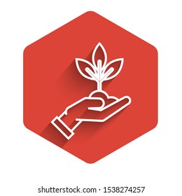 White line Plant in hand of environmental protection icon isolated with long shadow. Seed and seedling. Planting sapling. Ecology concept. Red hexagon button. Vector Illustration