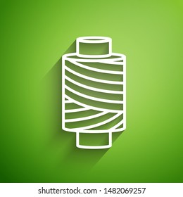White line Sewing thread on spool icon isolated on green background. Yarn spool. Thread bobbin.  Vector Illustration
