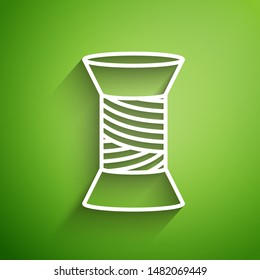 White line Sewing thread on spool icon isolated on green background. Yarn spool. Thread bobbin.  Vector Illustration