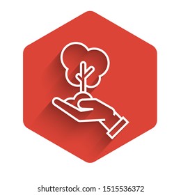 White line Tree in hand of environmental protection icon isolated with long shadow. Seed and seedling. Planting sapling. Ecology concept. Red hexagon button. Vector Illustration
