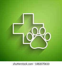 White line Veterinary clinic symbol icon isolated on green background. Cross hospital sign. A stylized paw print dog or cat. Pet First Aid sign.  Vector Illustration