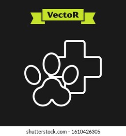 White line Veterinary clinic symbol icon isolated on black background. Cross hospital sign. Stylized paw print dog or cat. Pet First Aid sign.  Vector Illustration