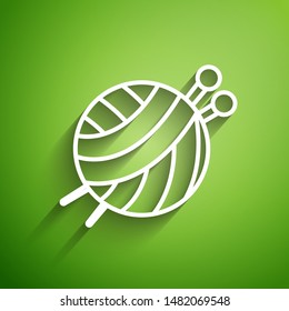 White line Yarn ball with knitting needles icon isolated on green background. Label for hand made, knitting or tailor shop.  Vector Illustration