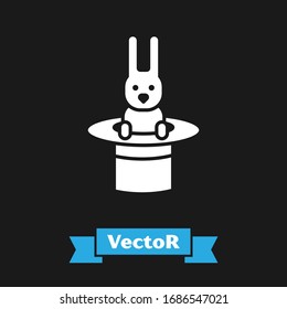 White Magician hat and rabbit icon isolated on black background. Magic trick. Mystery entertainment concept.  Vector Illustration