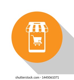 White Mobile phone and shopping cart with striped awning icon isolated on white background. Online buying symbol. Supermarket basket symbol. Orange circle button. Vector Illustration