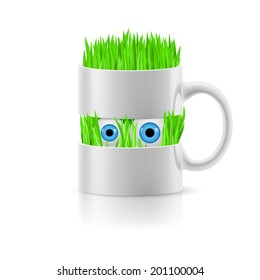 White mug divided into two parts with grass and two eyes inside.