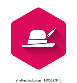 White Oktoberfest hat icon isolated with long shadow. Hunter hat with feather. German hat. Pink hexagon button. Vector Illustration