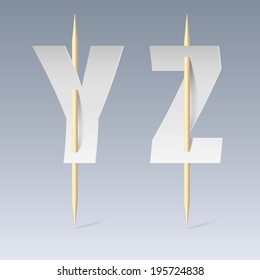 White paper cut font on toothpicks on grey background. Y and Z letters