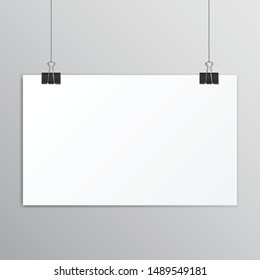 White paper hanging on a black paper clip with shadow on grey background.