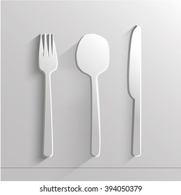 white paper knife spoon and fork on a  light background