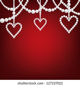 white pearl necklace and heart on red background