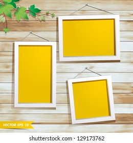 White photo frame on wood background, With green leaves decoration design