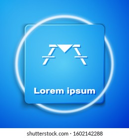 White Picnic table with benches on either side of the table icon isolated on blue background. Blue square button. Vector Illustration