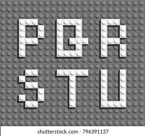 White plastic letters from building lego bricks. Gray lego background