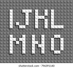 White plastic letters from building lego bricks. Gray lego background