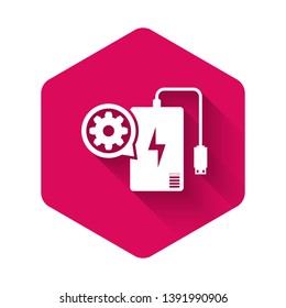 White Power bank with charge cable and gear icon isolated with long shadow. Adjusting app, service concept, setting options, maintenance, repair. Pink hexagon button. Vector Illustration