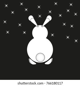 A white rabbit with a fluffy tail is depicted. With ears and paws on a black background with sparkling stars in the night sky.