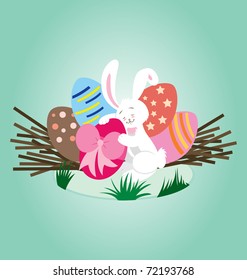 A white rabbit hugging a decorated egg with ribbon, with some other decorated Easter egg in the nest.